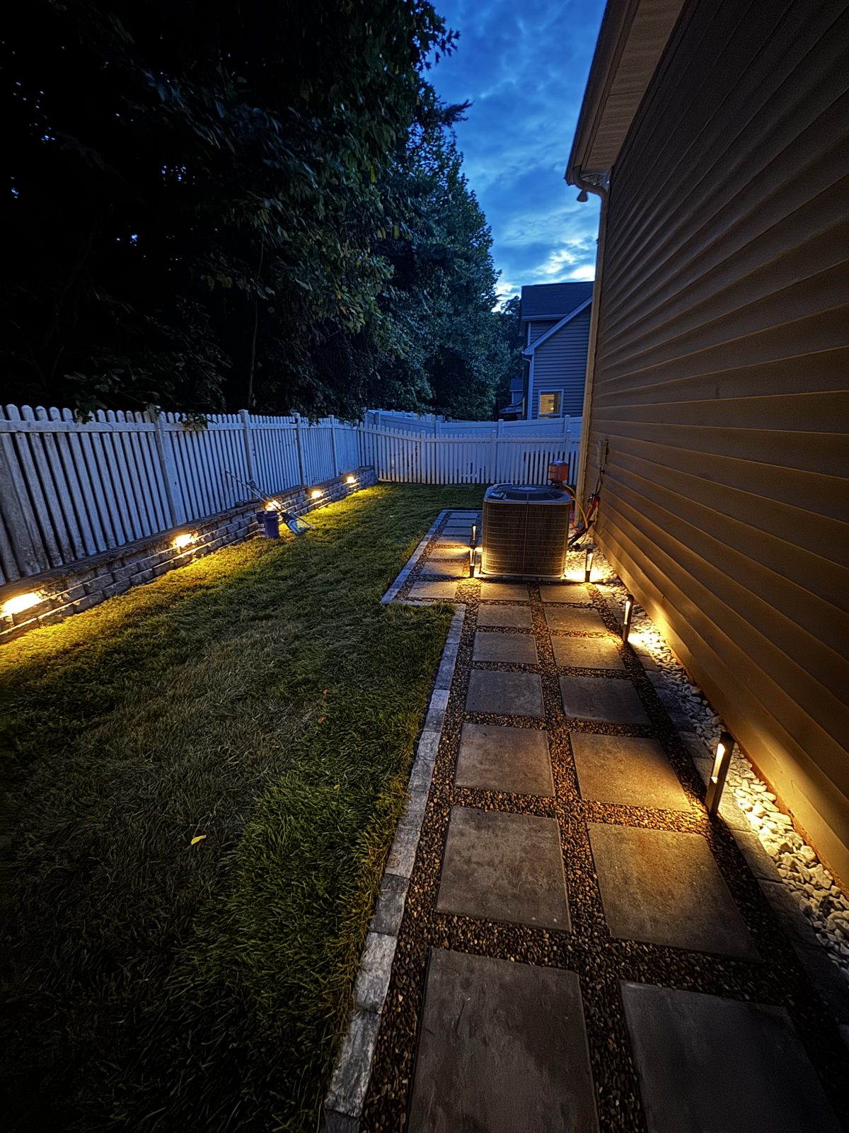 Finished terraced backyard with paver patio and lighting