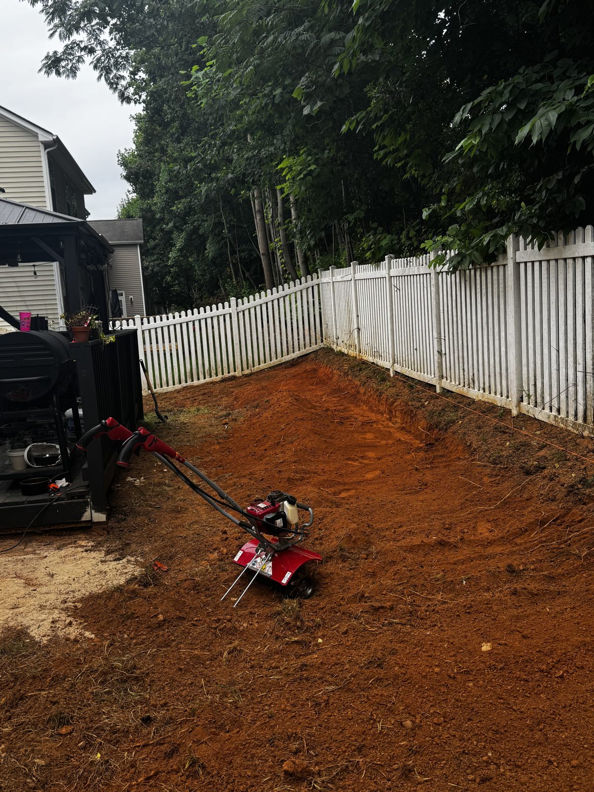Yard cleared and regraded to bare soil with a compact loader